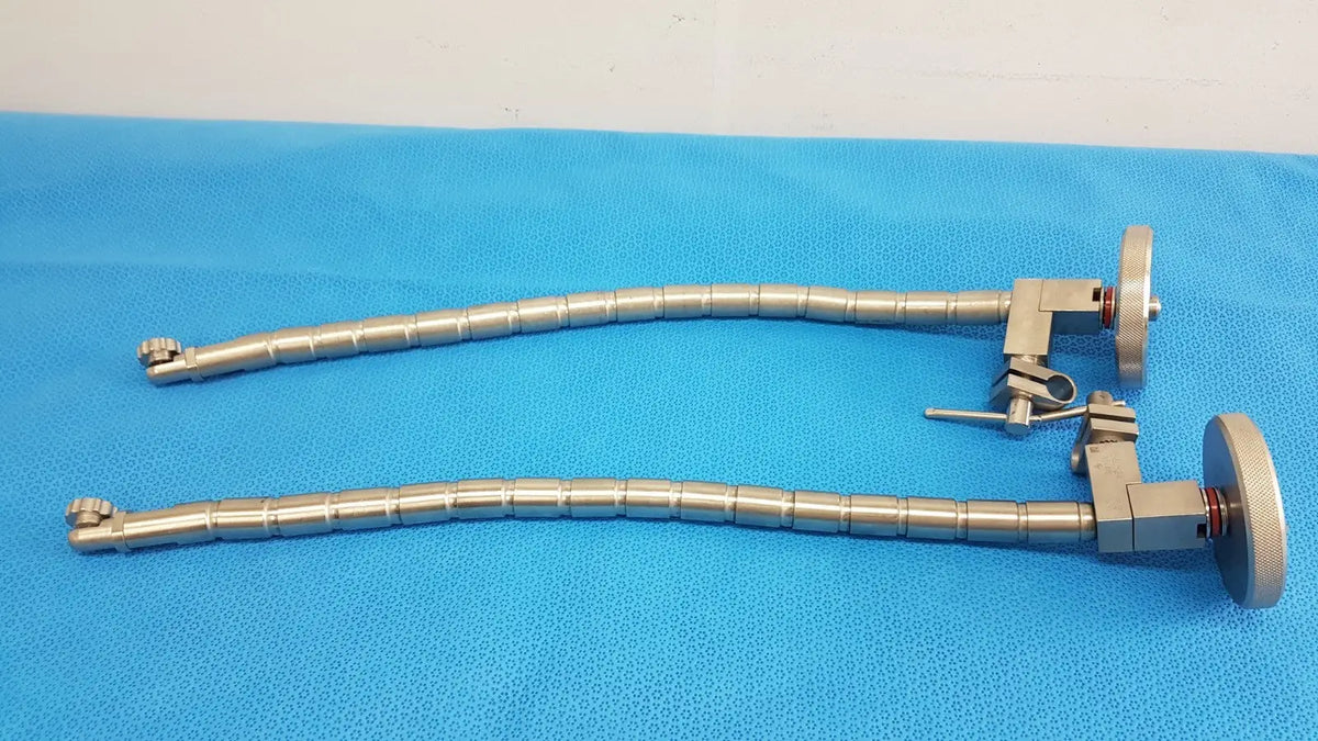 Two metallic silver surgical snake flexarm instruments with segmented joints and circular handpieces for OR use