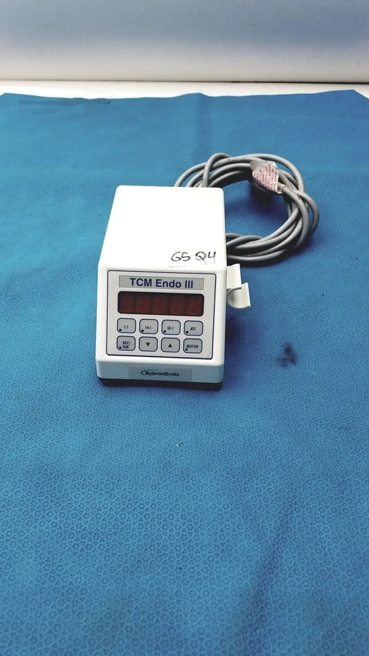 White plastic sybronendo tcm endo iii medical device with red digital display keypad and coiled gray tubing attached