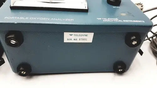 Blue teledyne portable oxygen analyzer with black knobs and white serial number label for accurate oxygen measurement