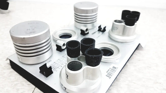 Silver and black cylindrical optical components on white tray of vaisala hmk15 humidity calibrator for probes and transmitters