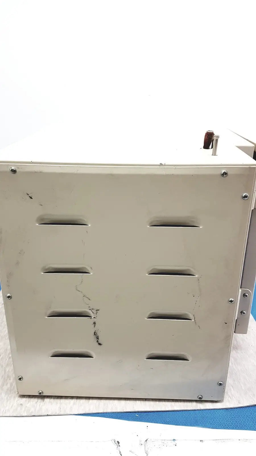 Beige metal scientific vacuum oven with horizontal ventilation slots and screws for electromotors laboratory use