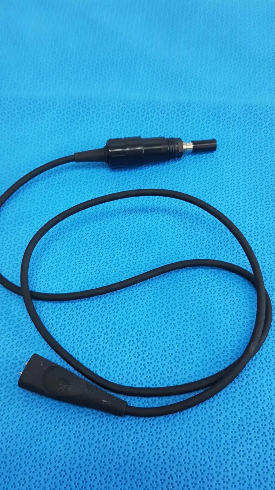 Black coiled welch allyn illuminator bulb cable with textured grip and metallic tip connectors for medical lighting use
