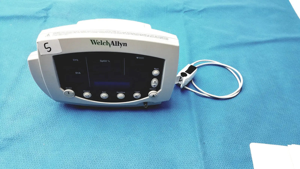 White Welch Allyn 300 series vital signs monitor with digital display control buttons and attached sensor cable for vital signs monitoring