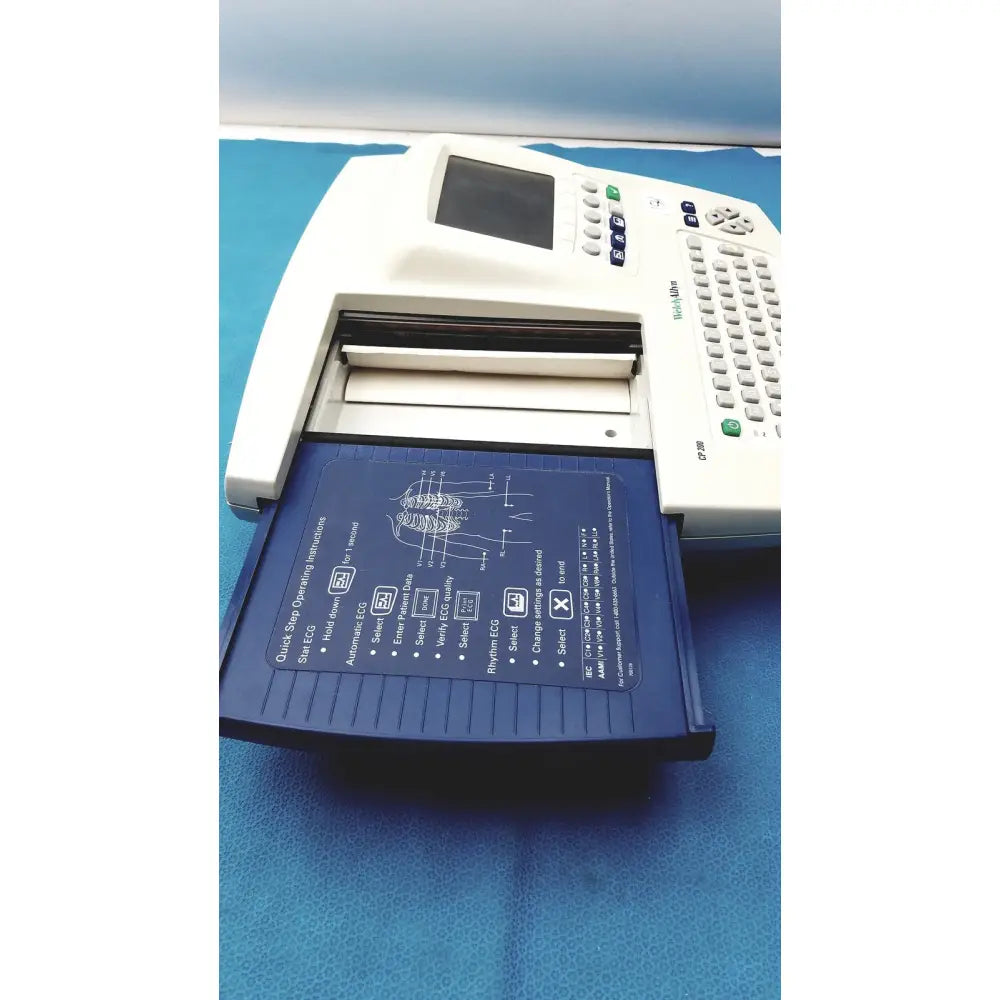 White welch allyn cp 200 ekg ecg monitor with blue tray displaying anatomical diagram and operating instructions
