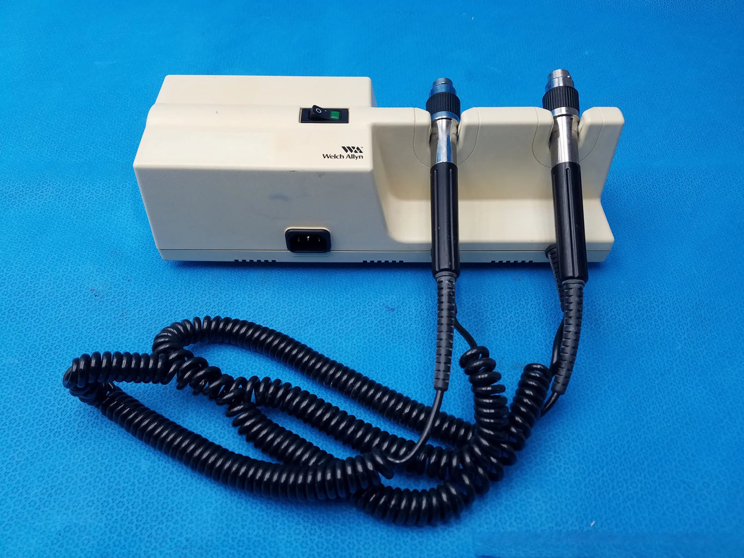 Cream-colored welch allyn series transformer with otoscope and ophthalmoscope featuring two diagnostic instruments and coiled cable