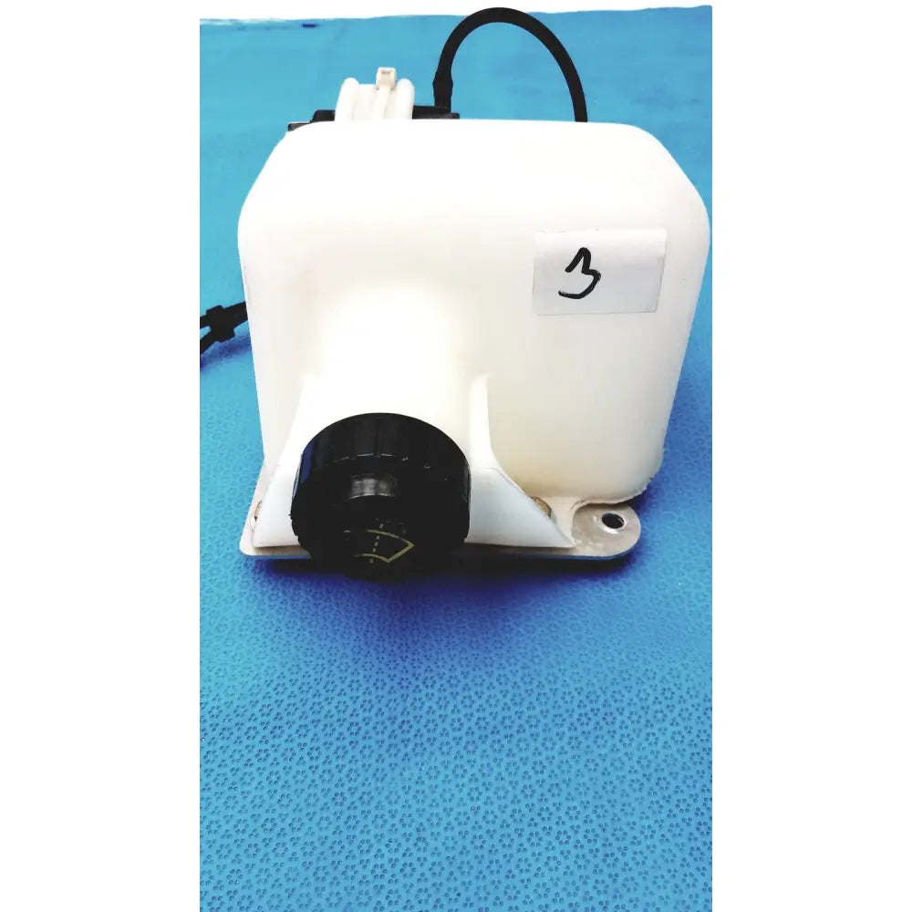White plastic windshield washer fluid reservoir tank with black cap and attached wiring for vehicle use