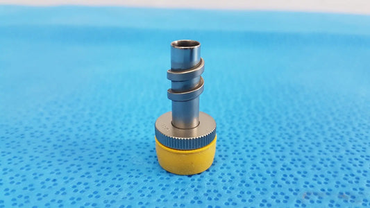Yellow and silver wolf stainless luer-lock tube connector with threaded metal fittings for surgical instrument use