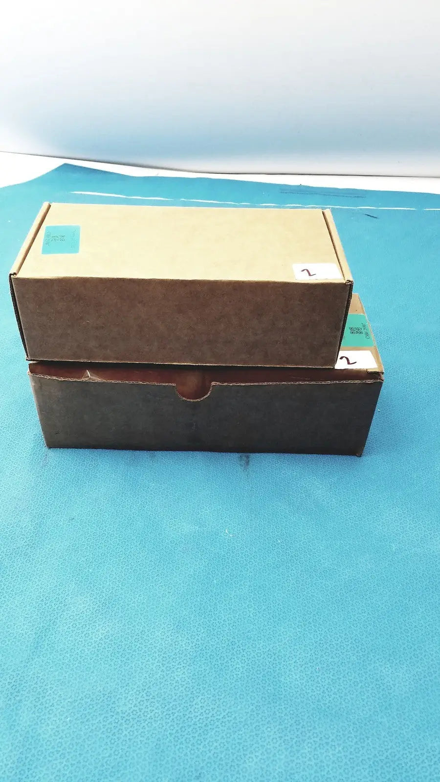 Two stacked cardboard boxes brown and dark with handle for zebra barcode scanner mt2070-sd4d62370wr with charger