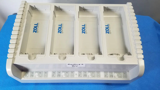 White plastic zoll defibrillator paddle tray with four compartments marked zoll for zoll surepower 4 bay charger station ipx1