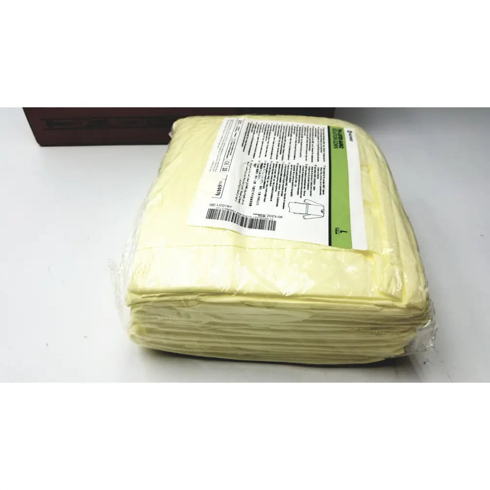 A package of pale yellow disposable absorbent pads sealed in clear plastic for 100 count case halyard tri isolation gown