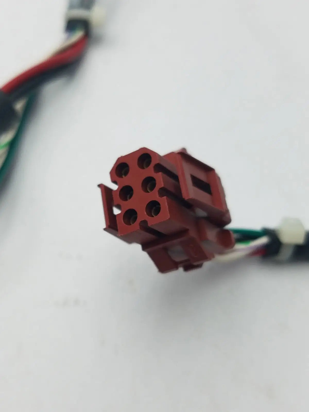 Red plastic 14 pin female connector with six circular openings and rectangular housing for cable harness and wire connector cable