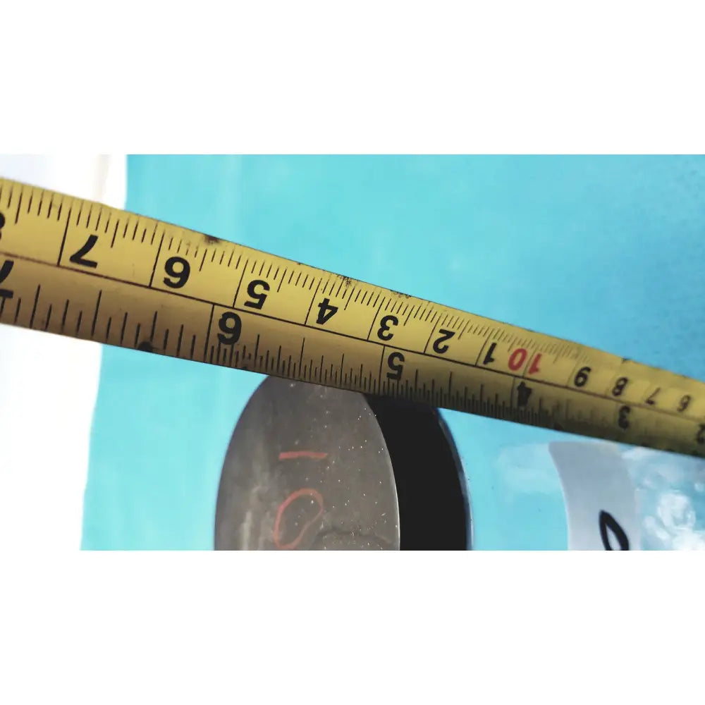 Yellow metal tape measure with black markings and red numbers next to 16 oz glass juice bottles set of 8 reusable containers