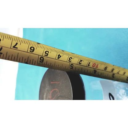 Yellow metal tape measure with black markings and red numbers next to 16 oz glass juice bottles set of 8 reusable containers