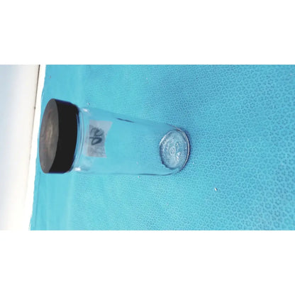 Clear glass juice bottle with black screw-on cap and silver label part of 16 oz glass juice bottles set