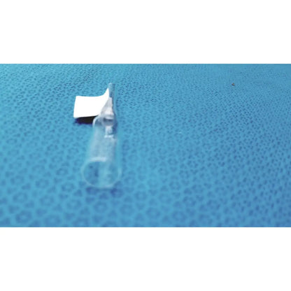 1ml clear glass ampoule low borosilicate with white cap lying on a blue textured surface
