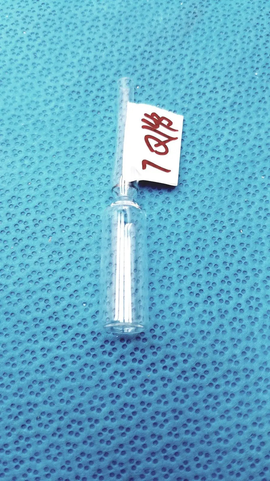 1ml clear glass ampoule low borosilicate with narrow neck and white solid inside cylindrical clear glass vial