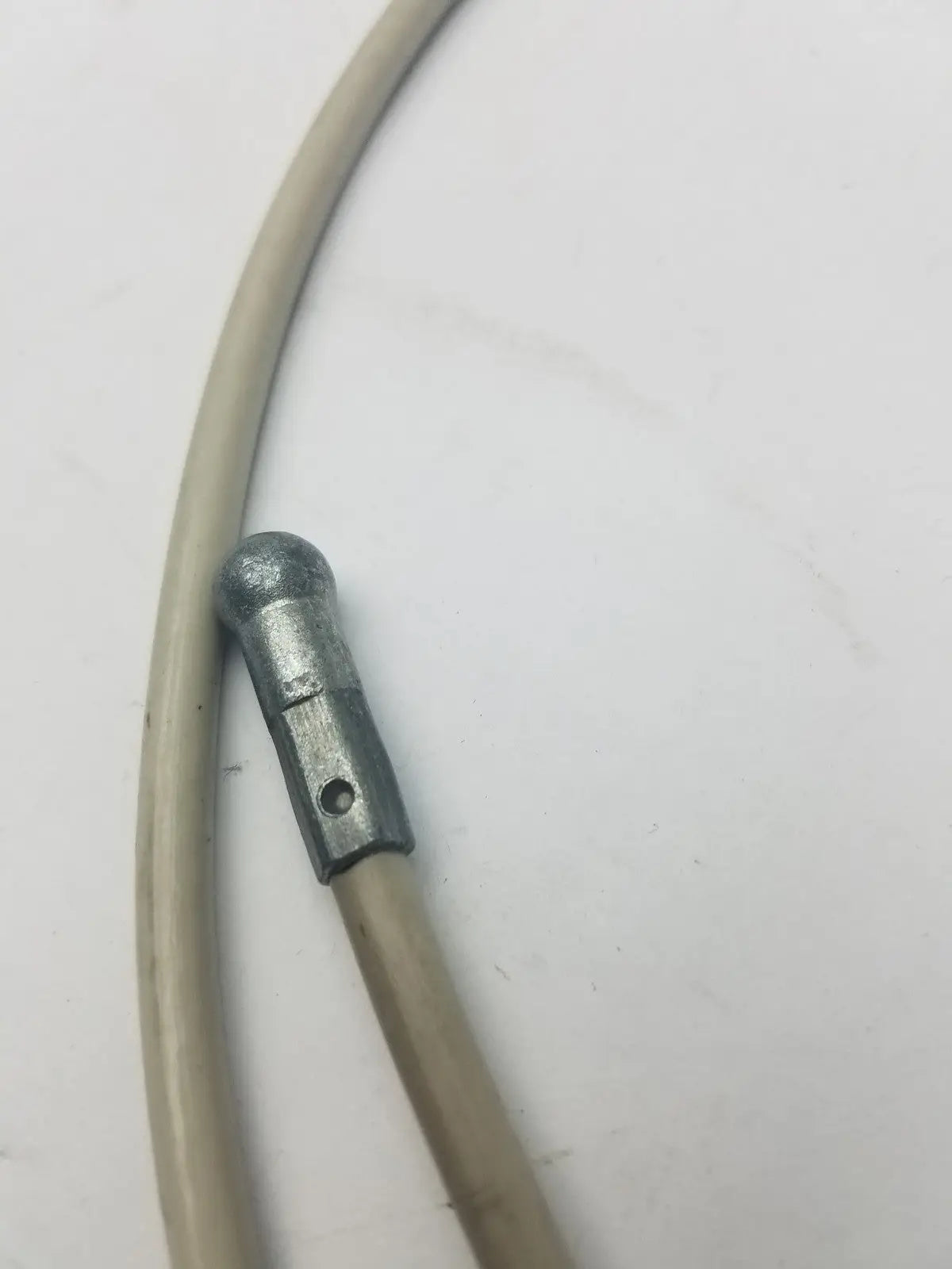 Gray metallic brake cable housing with silver rounded end cap and hole for attachment for sided cable g-bbdf6-59n