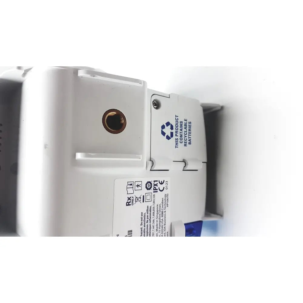 White plastic wall-mounted covidien kangro epump with brass circular port and recycling label serial c13078066 back side