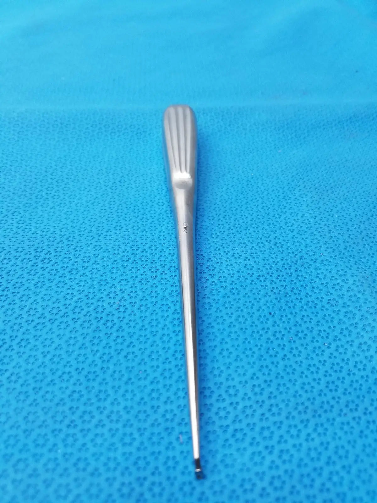 A sleek stainless bone curette spratt bone curette with ribbed handle and tapered shaft for surgical orthopedic use
