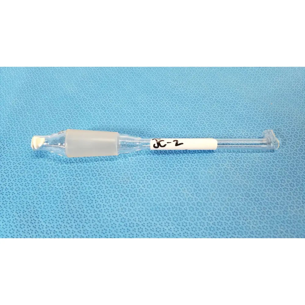 Clear glass thermometer adapter with translucent gray plastic cap and white label marked x-2 for lab thermometry use