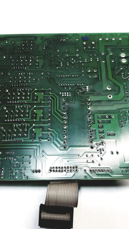 Green printed circuit board with silver soldered components and flexible ribbon cable connector on 2p8414t mother board