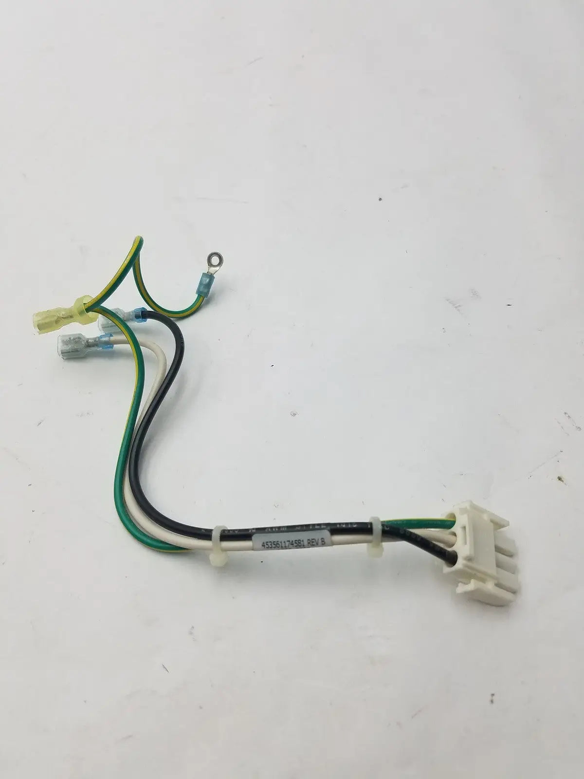 White plastic 3 pin female connector with green and black wires and label 45986174sbi on 4 wire cable rev b
