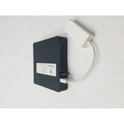 Black rectangular external hard drive connected with white 3 pin female connector cable and power adapter attached