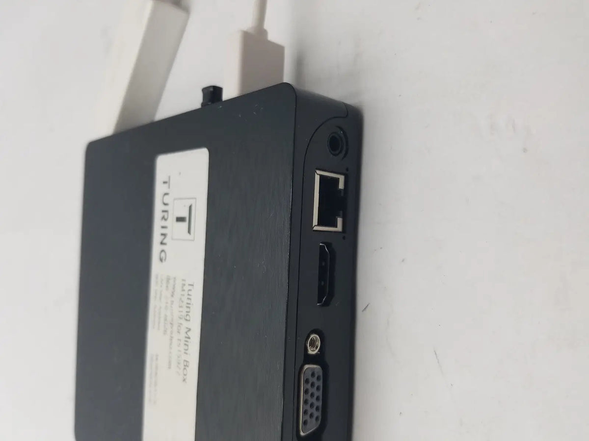 Black mini box showing backside with multiple ports including ethernet hdmi and vga featuring a pin female connector cable