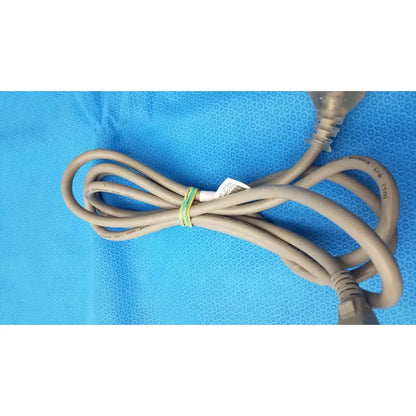 A beige 3-prong power cable standard ac cord with plastic plug and label secured by green and yellow tie