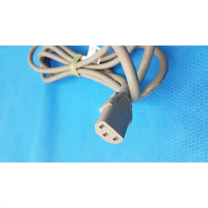 Gray 3-prong power cable coiled and secured by a yellow tie standard AC cord tested for reliability