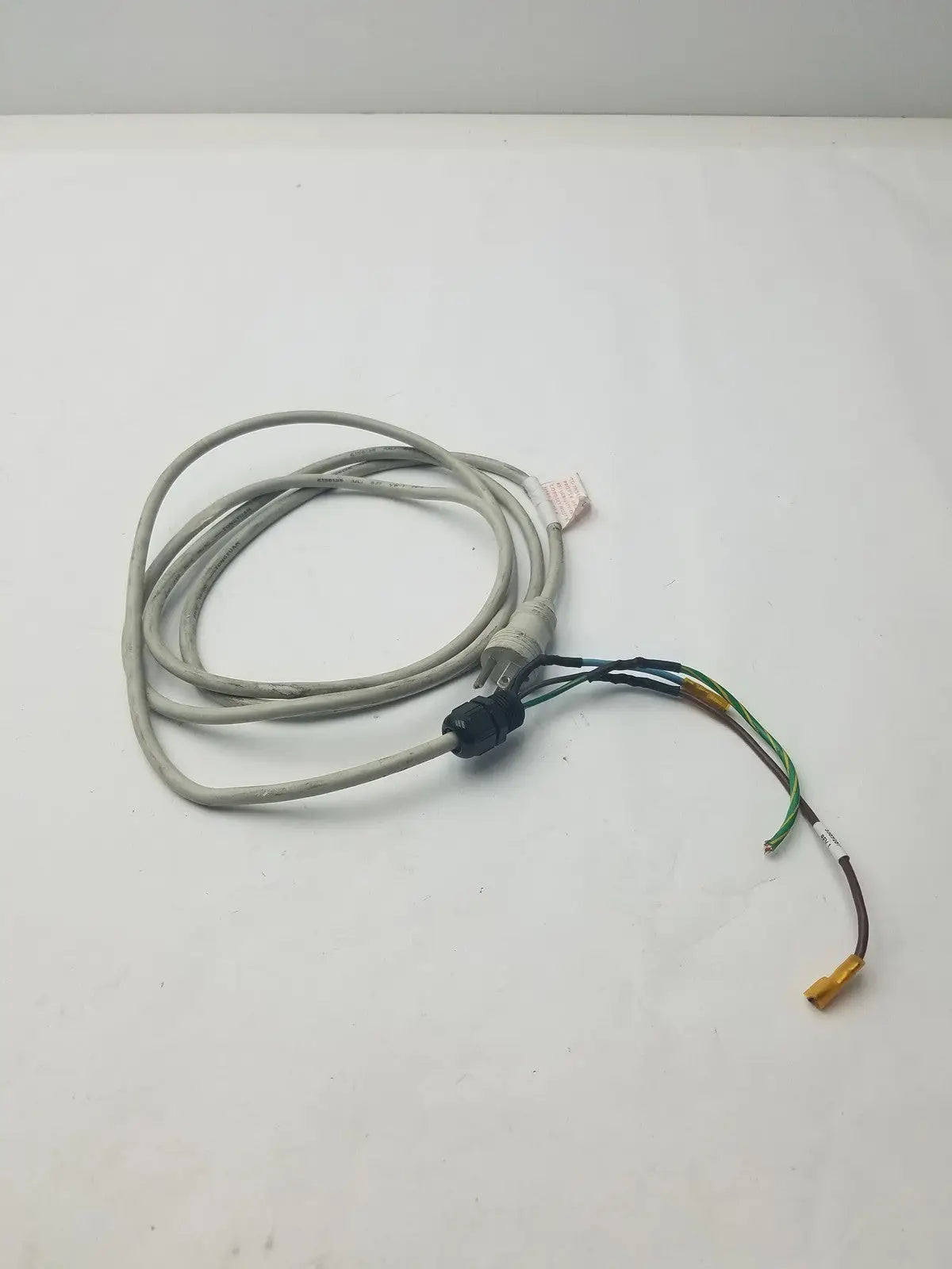 Gray coiled 3 prong power cable with black connector and exposed multi-colored wires in a wire connector harness