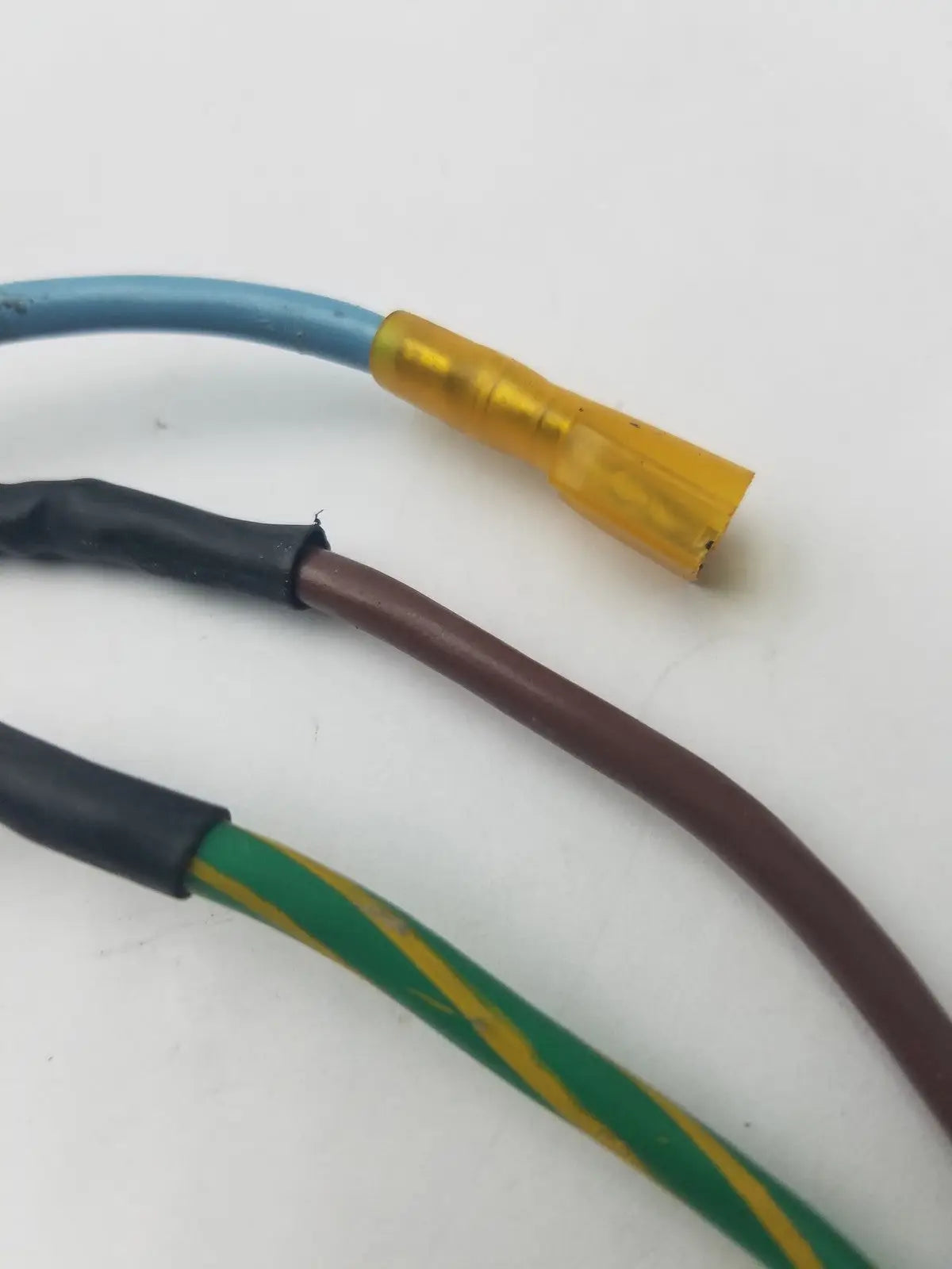 Three insulated wires in blue black and green-yellow with a yellow crimped connector for 3 prong power cable harness