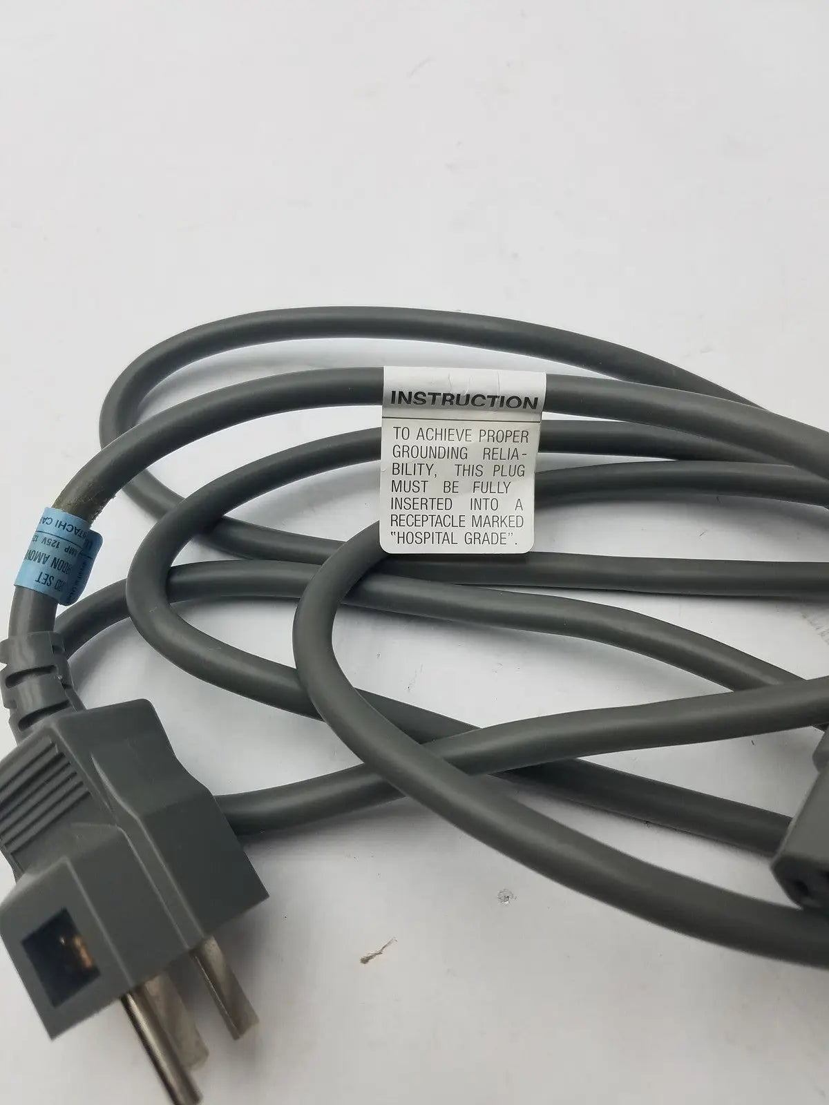 Gray hospital-grade 3 prong power cord detachable cable with instruction label for reliable medical use