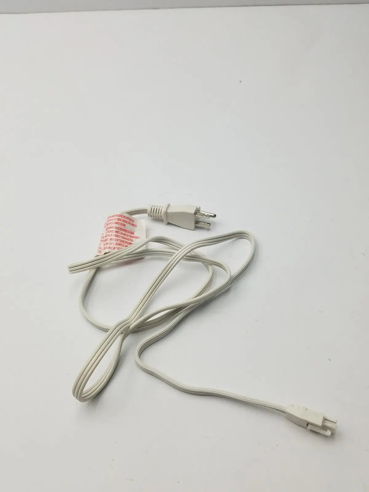 White power extension cord with two molded plastic plugs featuring a three-prong and smaller connector design