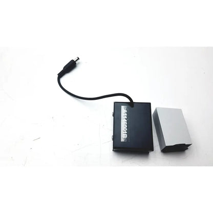 Black rectangular power adapter with silver label and cable next to metallic gray battery pack for calibration kit a1146001b