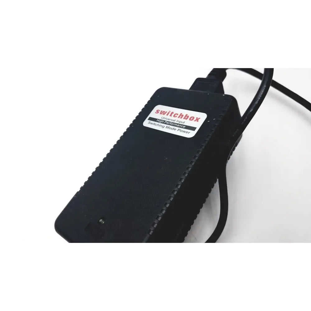 Black switchbox power adapter with textured surface and coiled cable for 3 shape calibration kit a1146001b use