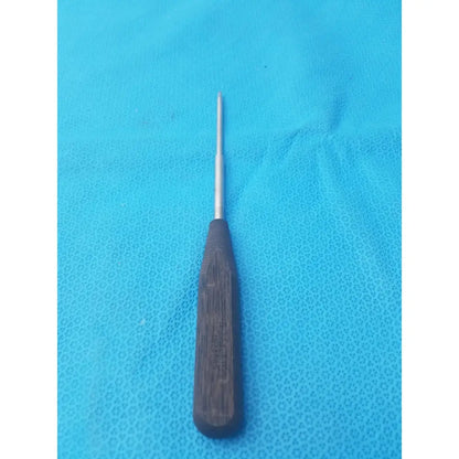 A dark brown wooden-handled hex screwdriver stainless surgical instrument with slender metallic shaft and pointed tip
