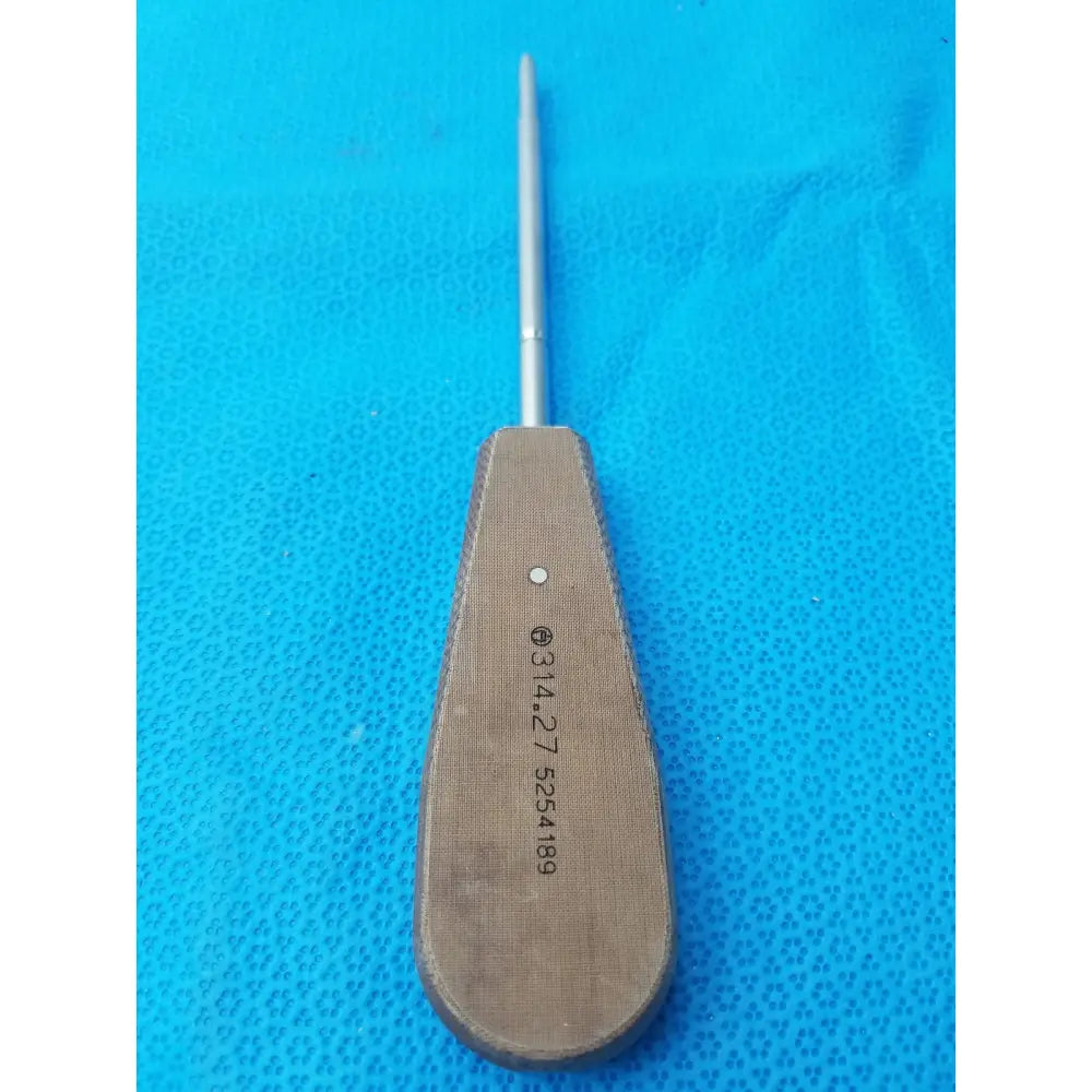 A metallic surgical instrument hex screwdriver stainless steel with a textured tan handle and slender silver shaft