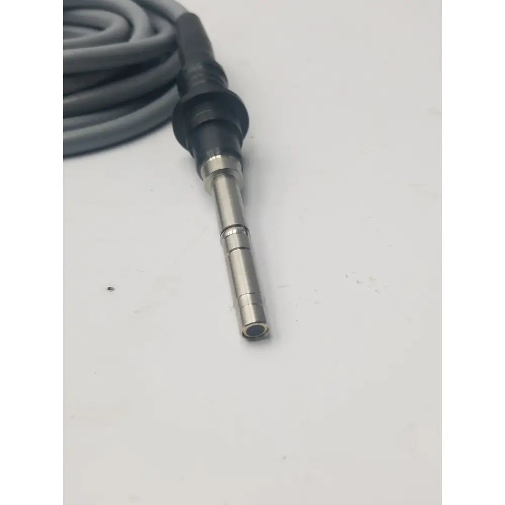 Gray fiber optic light guide cable coiled with black and metallic connector for precise light transmission