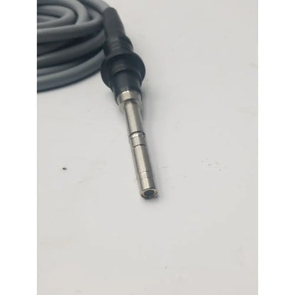 Gray fiber optic light guide cable coiled with black and metallic connector for precise light transmission