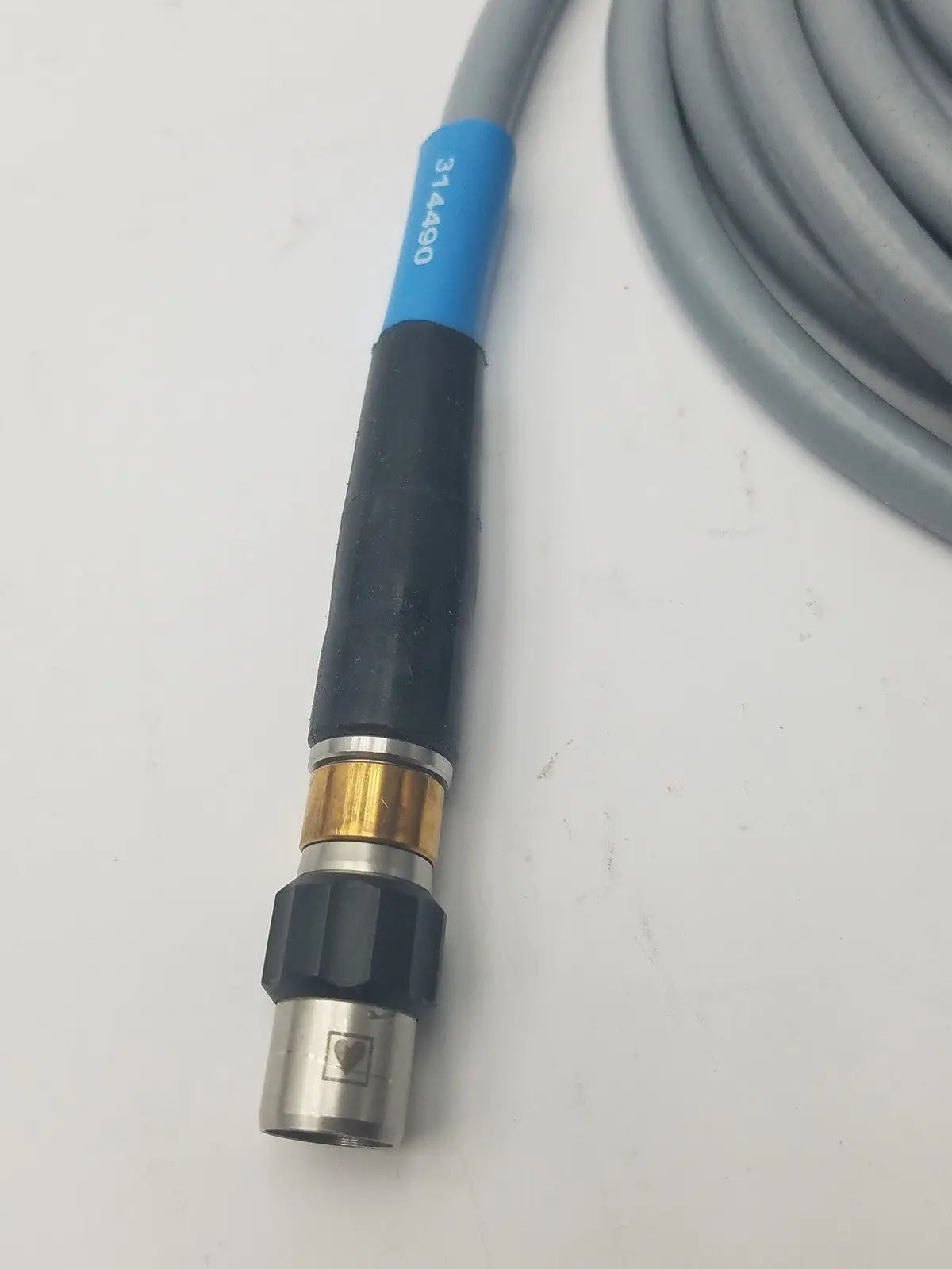 Gray and black high-pressure fiber optic light guide cable hose with blue label marked 314490 near the connector