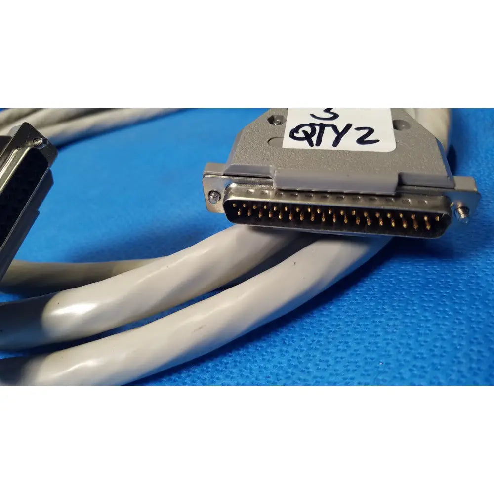 Gray d-sub 25-pin connector data cable with metallic pins and white label featuring female pin connector details