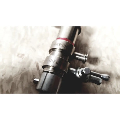 Silver metallic 3M 83272 pressure dispensing cannula with engraved press and infl markings and red rubber band