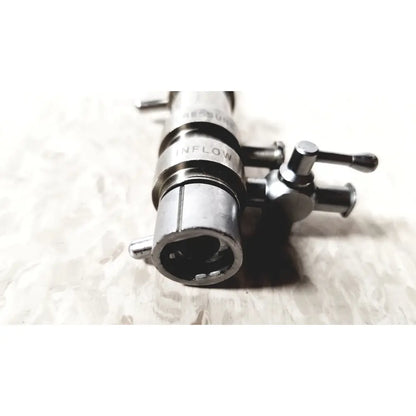 Silver metallic 3M 83272 pressure dispensing cannula with engraved inflow label and dual rotating stopcock knobs