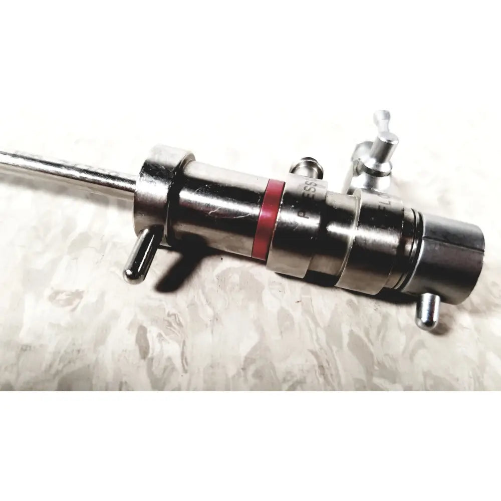 Silver metallic 3M 83272 pressure dispensing cannula with red band and engraved markings featuring rotating stopcocks