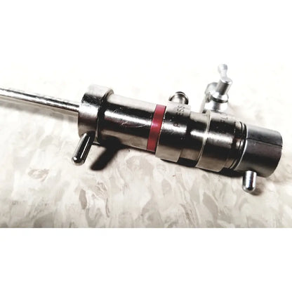 Silver metallic 3M 83272 pressure dispensing cannula with red band and engraved markings featuring rotating stopcocks