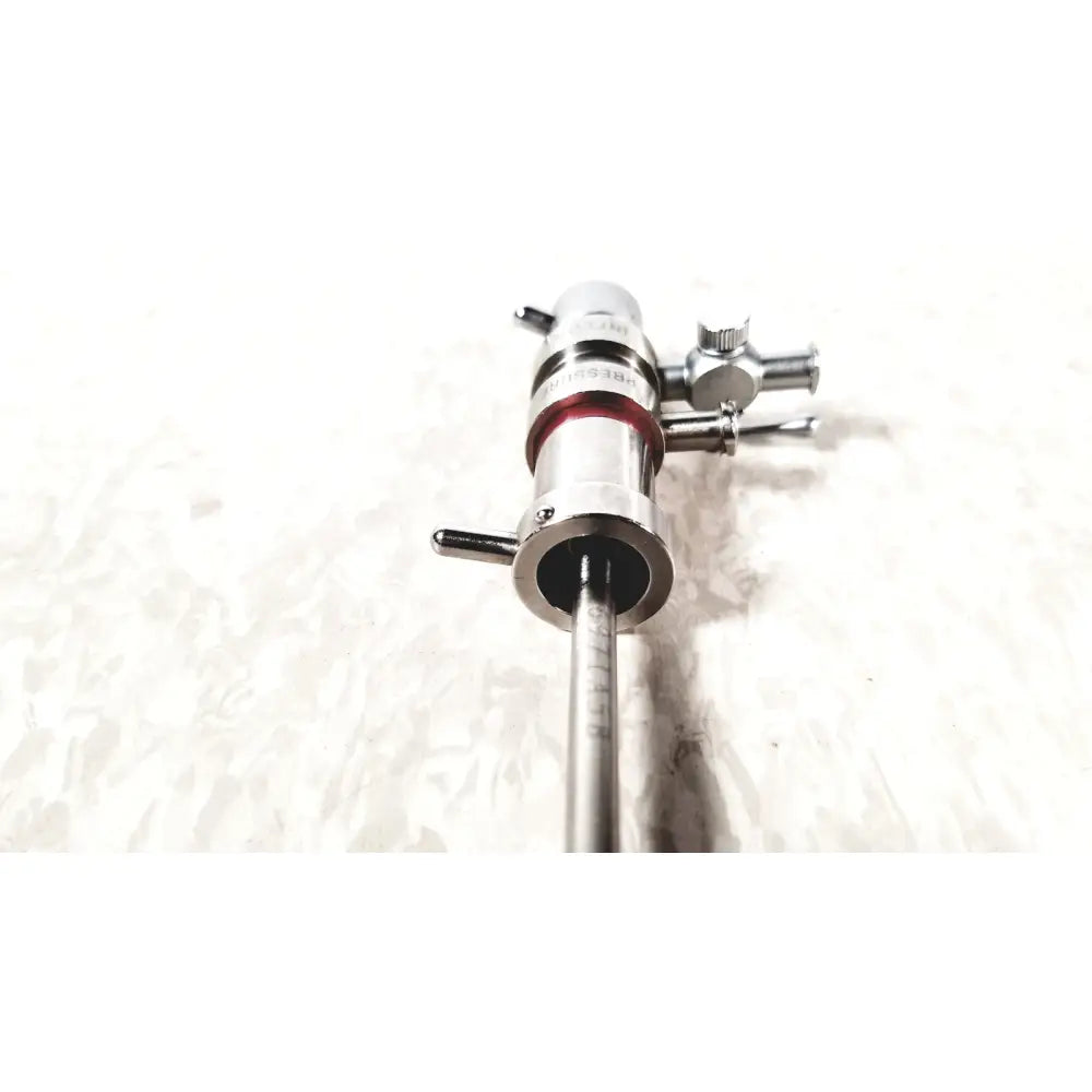 Silver 3M 83272 pressure dispensing cannula with red band and engraved markings featuring rotating stopcocks