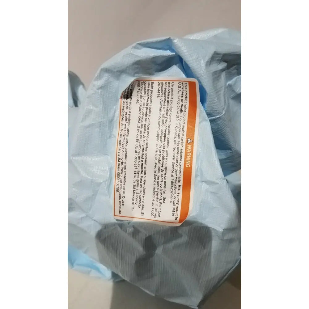 Blue plastic bag with orange warning label containing 3M BE-12LB blue respirator headcover for PAPR systems
