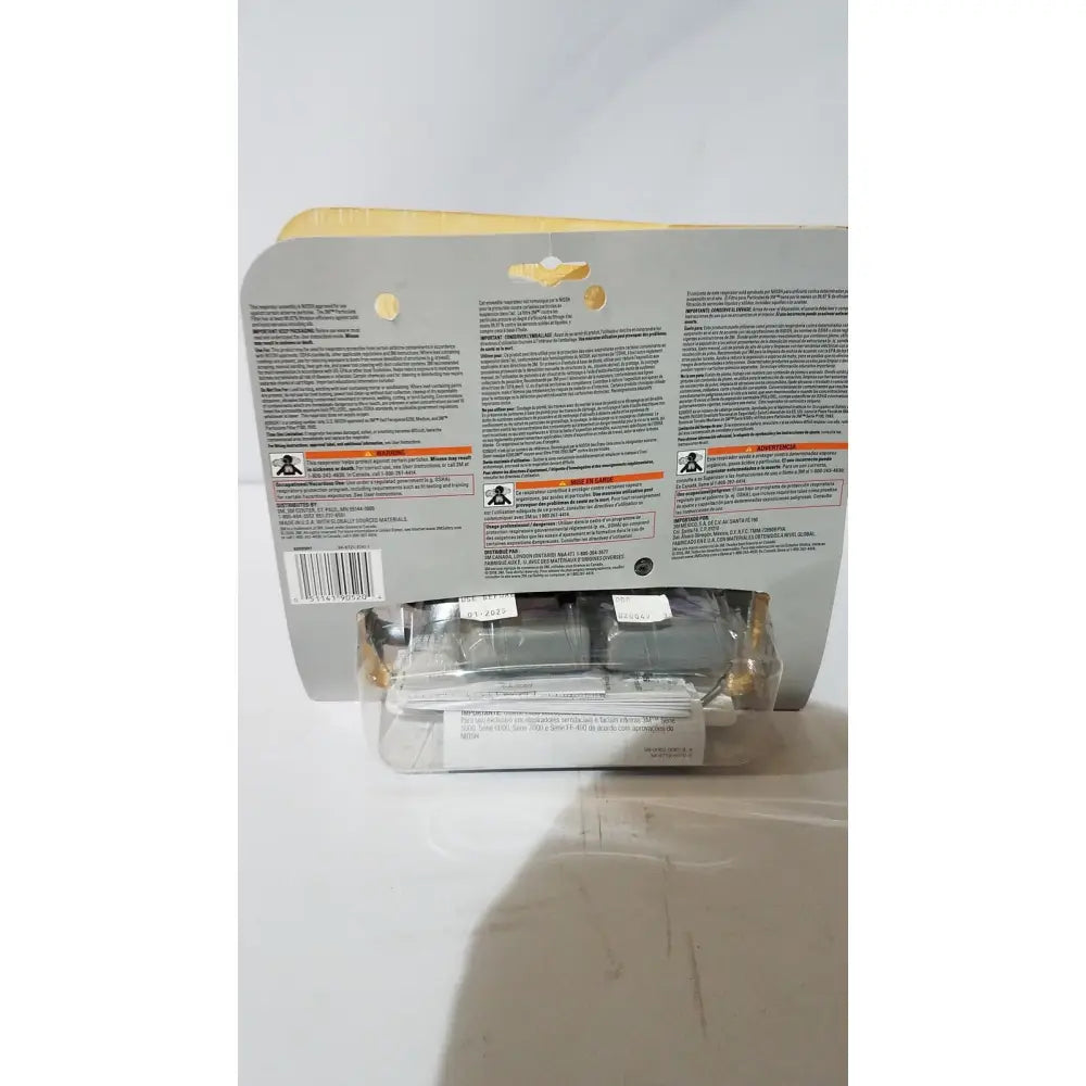 White plastic packaging of 3m medium half face reusable respirator with printed text and warning labels visible