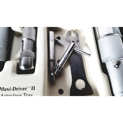 Silver metallic 3m maxi drive ii autoclave tray air powered instruments set neatly arranged in molded compartments